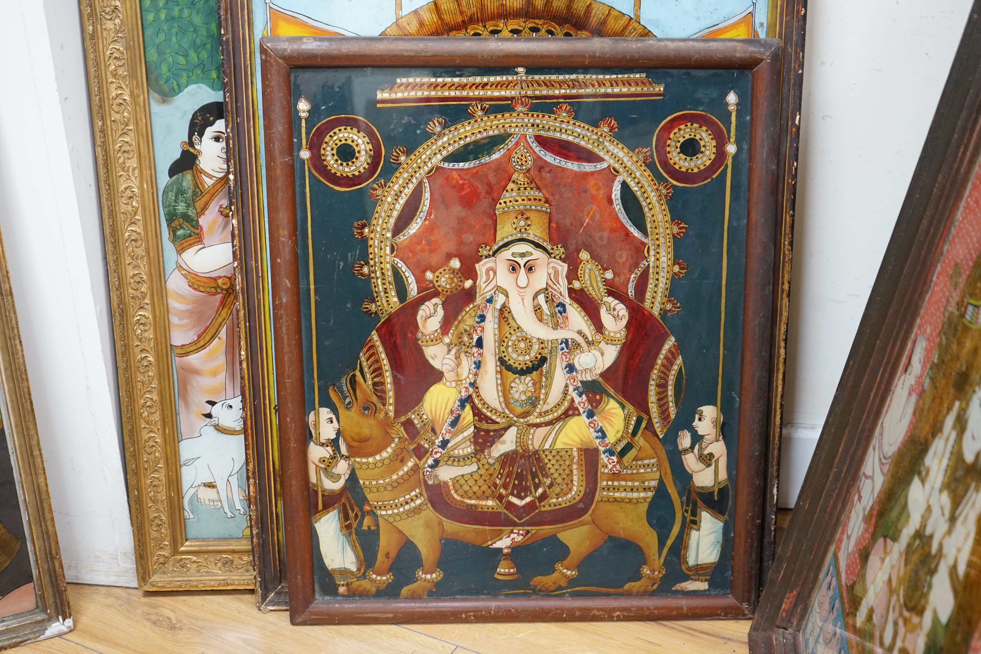 A collection of eight Indian reverse decorated glass pictures, 20th century, largest frame 70cm X 60cm